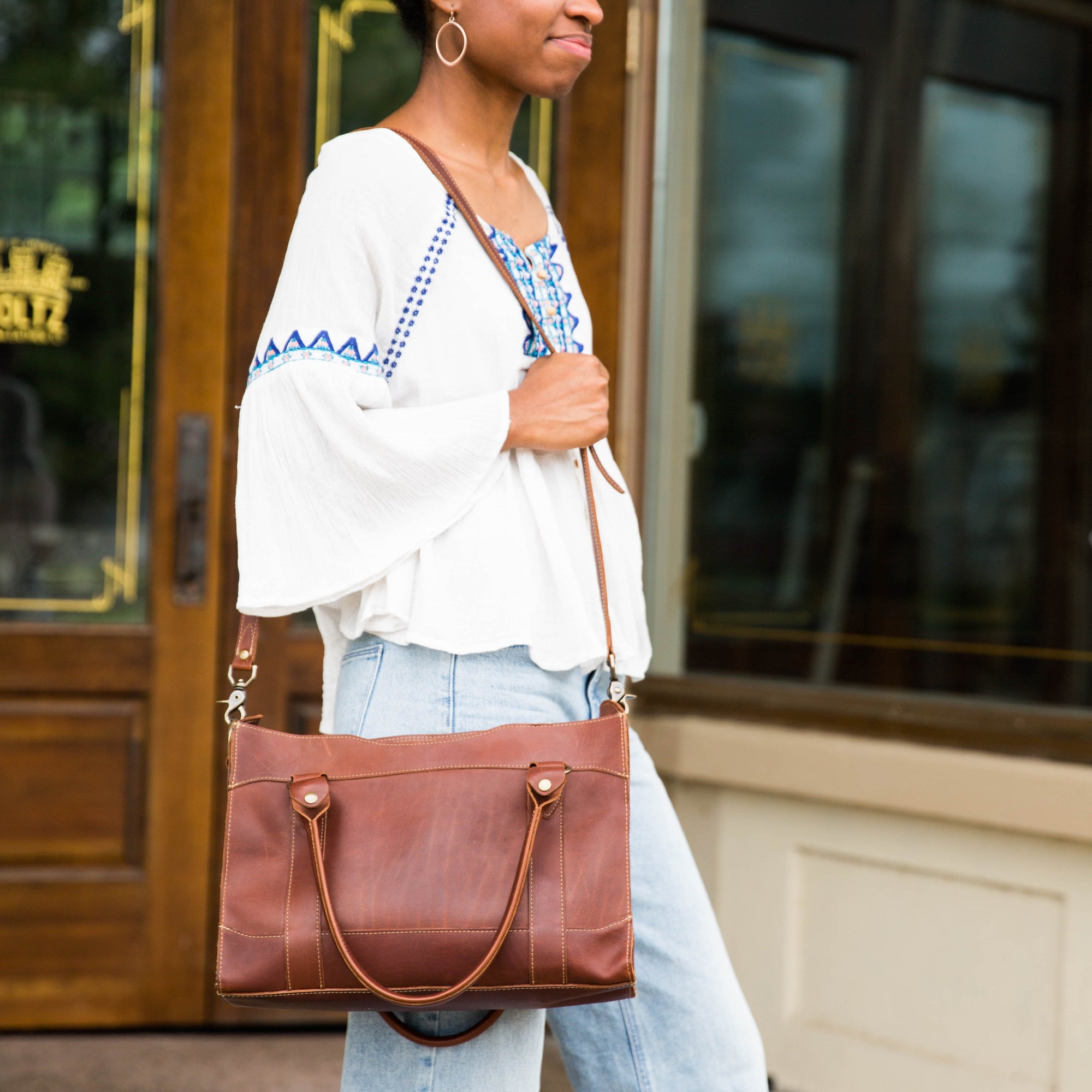 Fine leather handbag over a woman's shoulder at Holtz Leather Co in Huntsville, Alabama