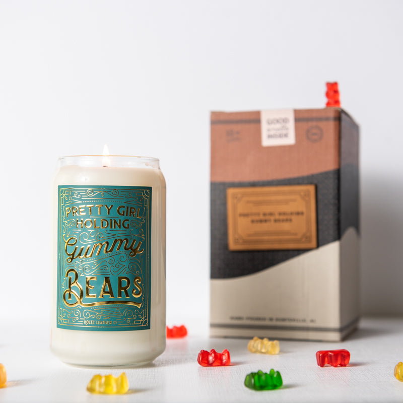 Pretty Girl Holding Gummy Bears scented candle in glass jar, surrounded by gummy bears